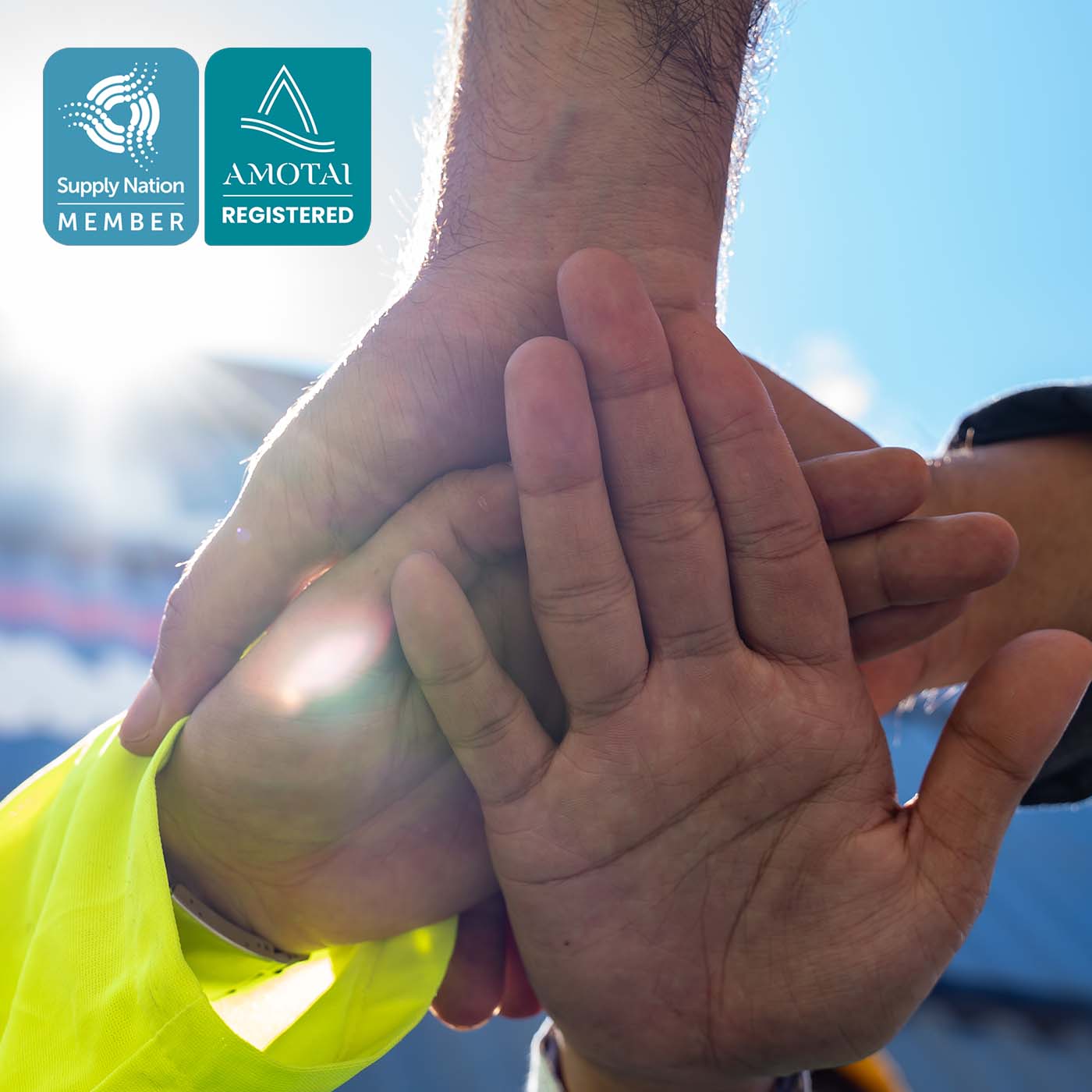 Close up view of a team of people with their hands stacked on top of each other together at a container yard. Close up view of a team of people with their hands stacked on top of each other together at a container yard.