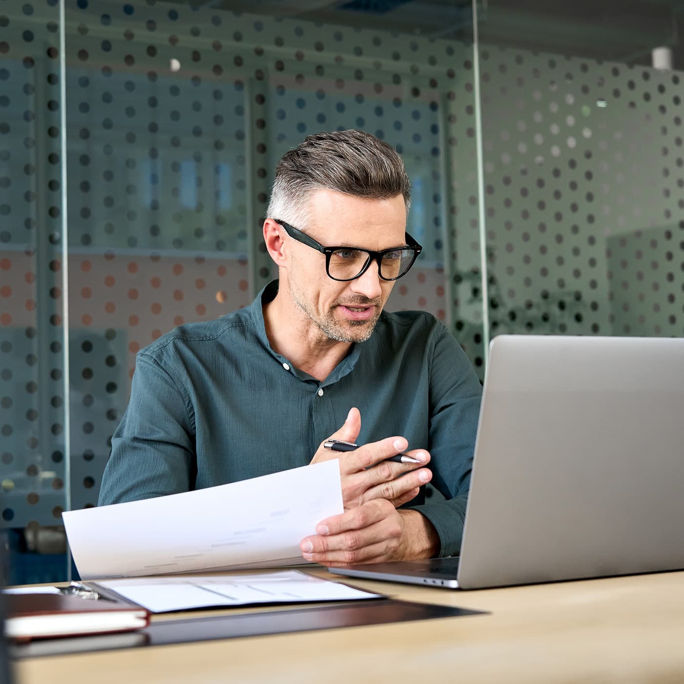 A male Account Manager using a laptop computer to have a video conference call with a customer. A male Account Manager using a laptop computer to have a video conference call with a customer.