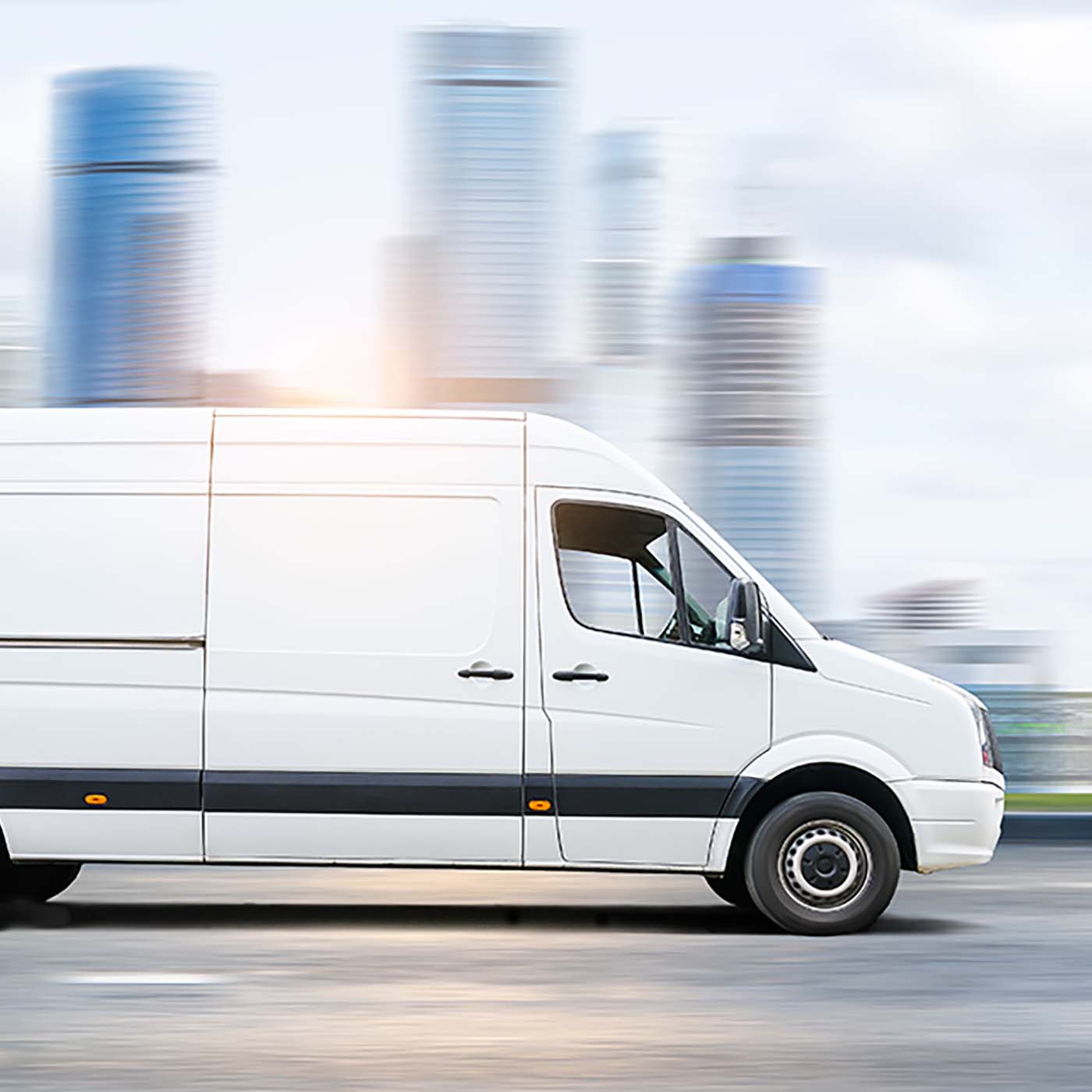 A white van moving through a city with the background blurred. A white van moving through a city with the background blurred.
