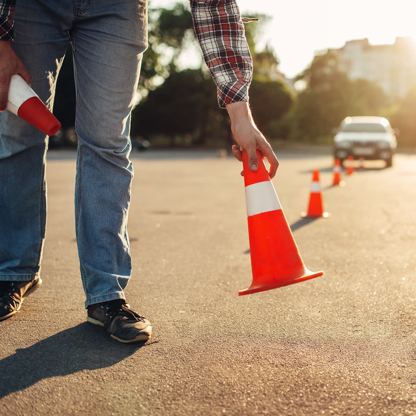 A driving instructor setting up cones, for a Defensive Driver Training program. A driving instructor setting up cones, for a Defensive Driver Training program.