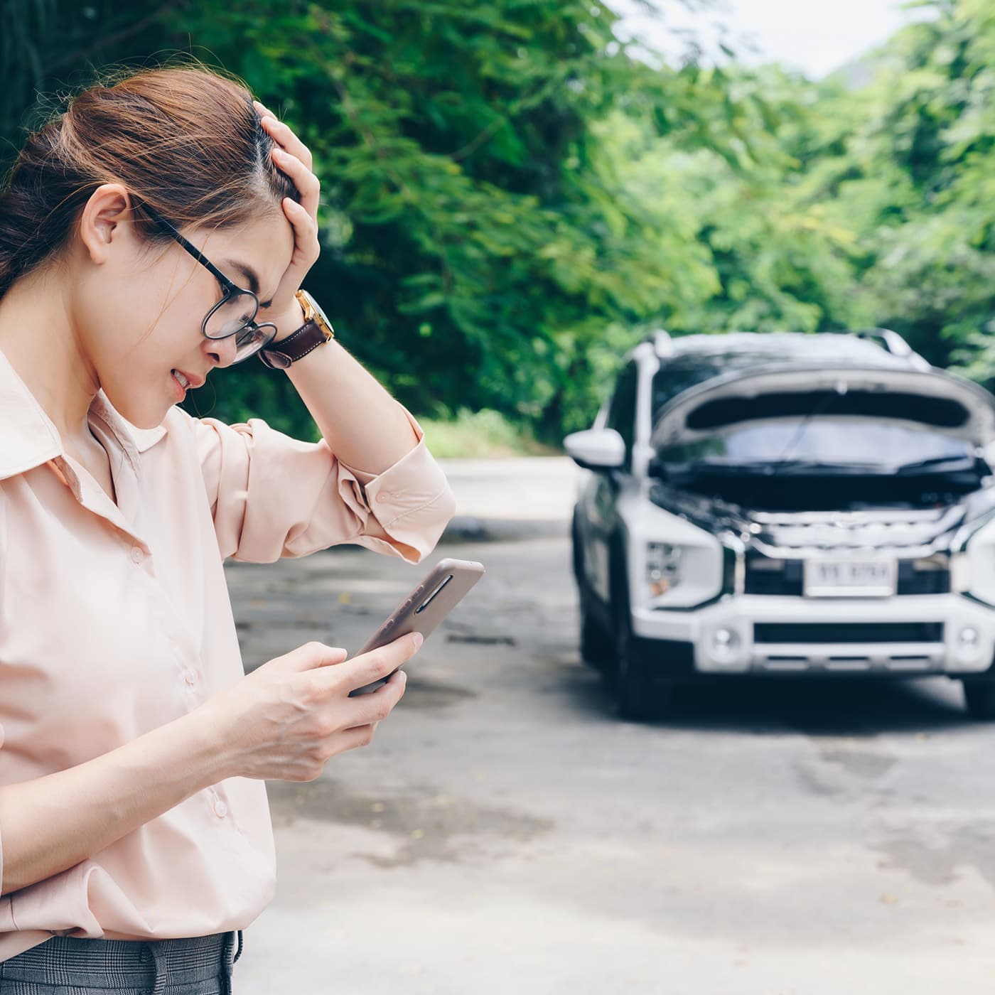 Asian woman calling Roadside Assistance to help with her car breakdown. Asian woman calling Roadside Assistance to help with her car breakdown.