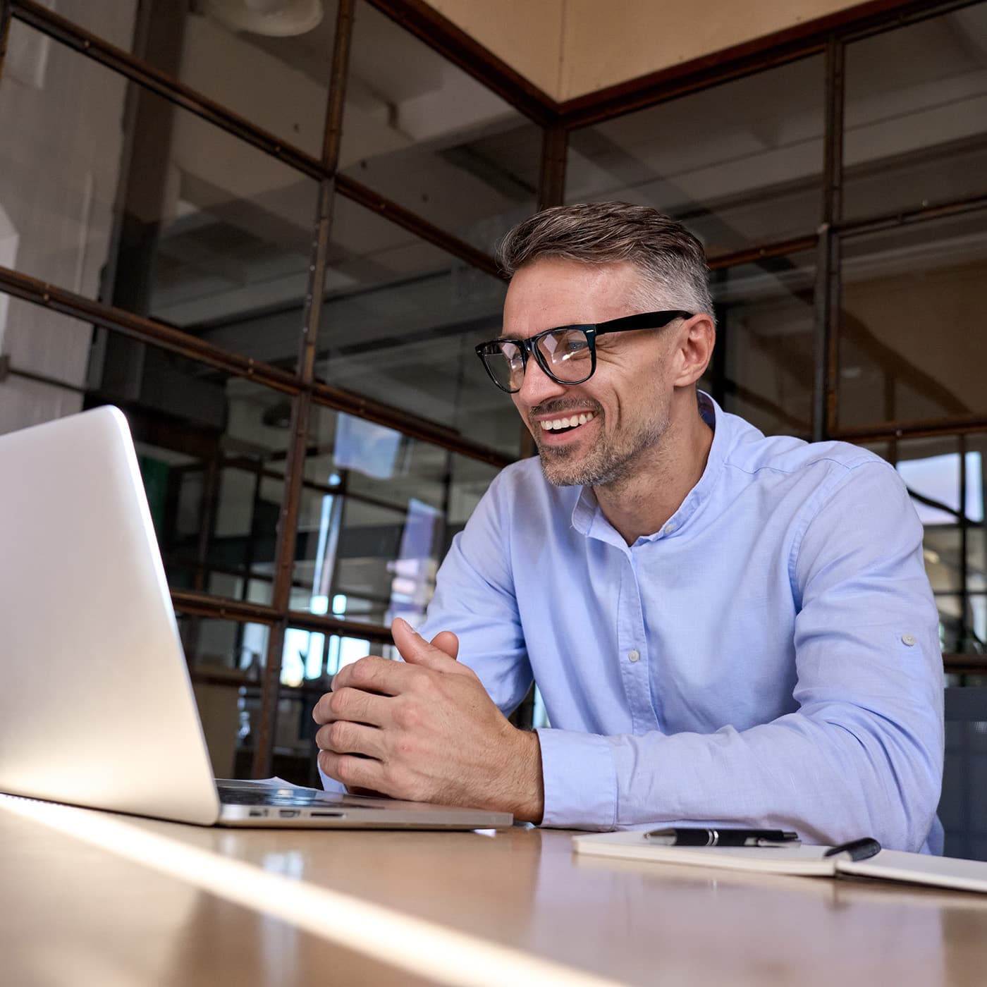 Happy mature business executive looking at his laptop to access the End of Lease portal to manage the return of his fleet vehicle. Happy mature business executive looking at his laptop to access the End of Lease portal to manage the return of his fleet vehicle.