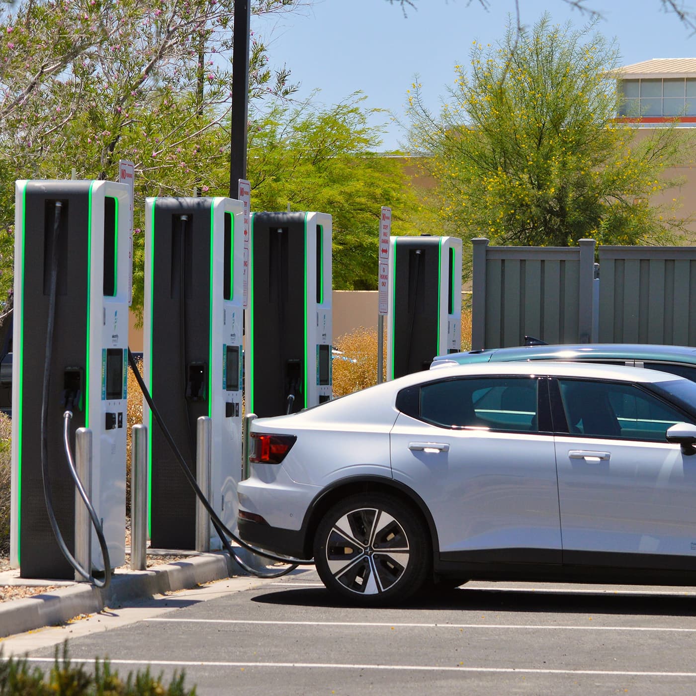 A Polestar 2 electric vehicle charging in a public parking area. A Polestar 2 electric vehicle charging in a public parking area.