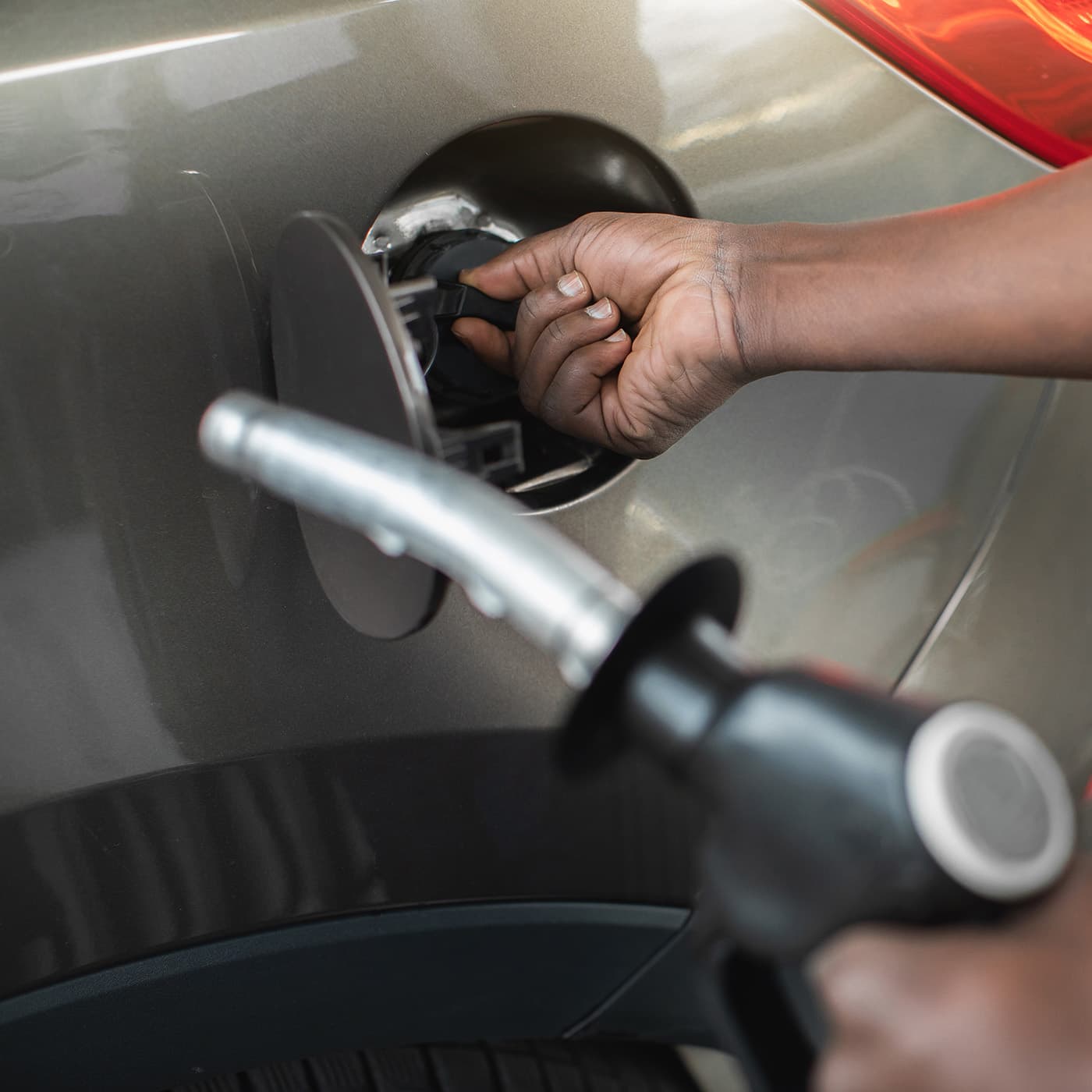 Close up cropped shot of a a man filling his car with fuel at a petrol station. Close up cropped shot of a a man filling his car with fuel at a petrol station.