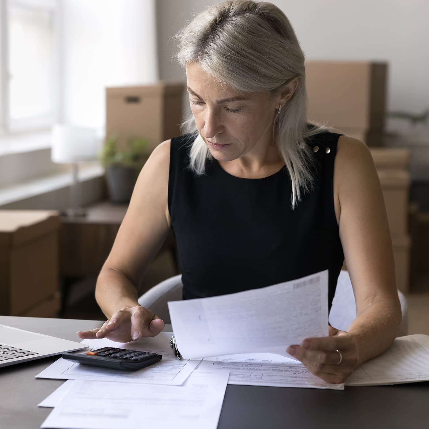 Woman sitting at an office desk, calculating fleet vehicle costs. Woman sitting at an office desk, calculating fleet vehicle costs.