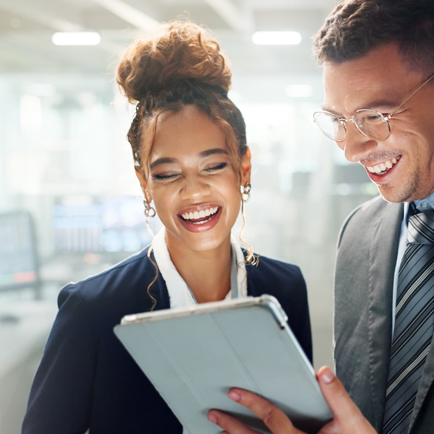 Two business people collaborating on fleet customer needs while looking at a tablet. Two business people collaborating on fleet customer needs while looking at a tablet.