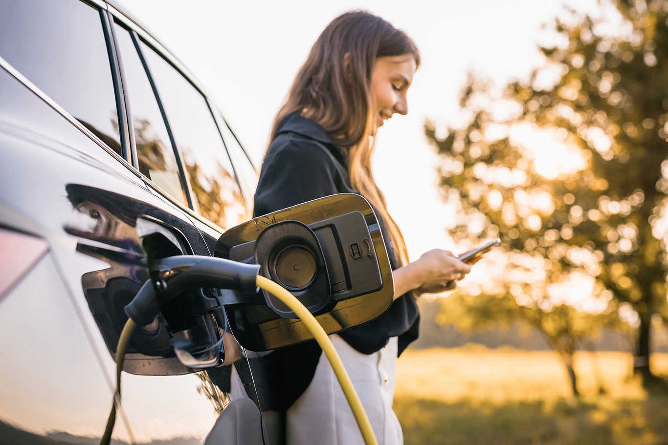 a woman charging her EV vehicle